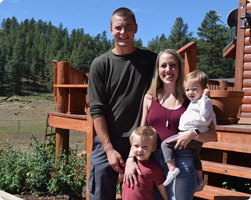 Family portrait in a natural outdoor setting featuring two adults and two children.